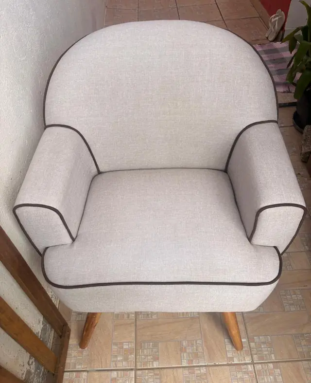 Poltrona cinza clara com debrum higienizada